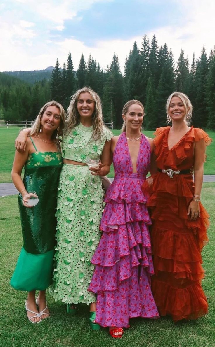 Invitées en robes colorées devant les sapins